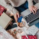 Woman shopping online surrounded by Christmas stuff